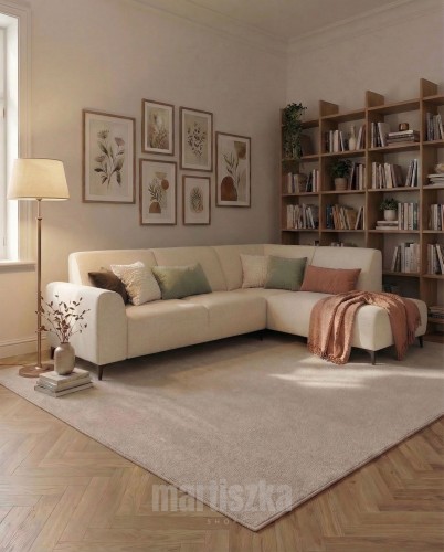 Elegancki beżowy narożnik szenilowy w ciepłym, stylowym wnętrzu z drewnianą biblioteczką i galerią plakatów botanicznych. Wygodna strefa wypoczynkowa idealna do relaksu.