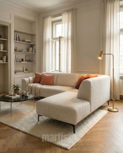 Przytulny, jasny salon z beżowym narożnikiem SENSO w tkaninie szenilowej. Prawostronna kanapa narożna z szezlongiem, ułożona na parkiecie w jodełkę, ozdobiona rudymi poduszkami dekoracyjnymi.